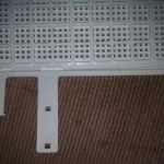 7: New bottom grid in place; now remove the excess side tabs. NOT with scissors - double ow! I used a Dremel.