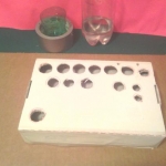 Juice box with holes cut and painted.