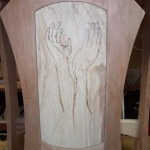 The hands of the potter burned into the face of the art stand.
