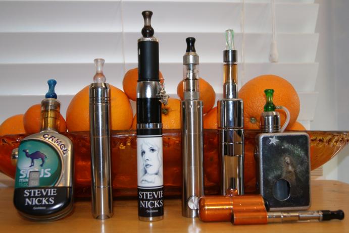 Fazed mod (Nivel chip), P18 (with an IGO-L on top), eVic with custom Jwrap and topped with a Vivi Nova tank, orange GLV Super Mini with Nano clearomizer, AltSmoke Omega with E1 tank, top feeder (with custom graphics) made by Shanmods and topped with another IGO-L.
