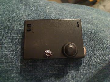 Front of the mod with the black button and the voltage adjustment dial.