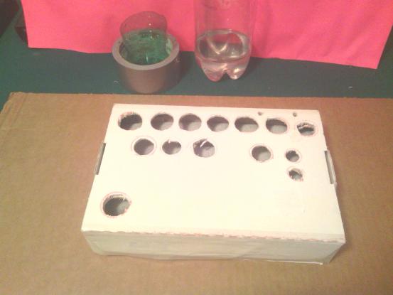 Juice box with holes cut and painted.