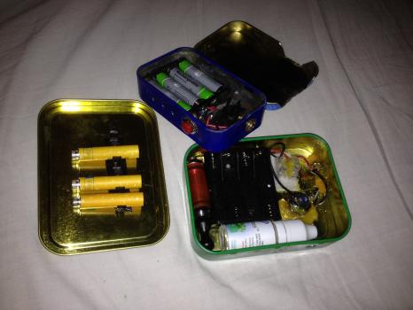 Picture of a couple of mods I've made.

The 1oz tin is a very straightforward 510 box mod with push button switch and is powered by a set of 4 aaa batteries, which gives it an output of around 4.5v. The lid is also cut back to make room for my AGA-t, which admittedly is not used very often.

I then made the 2oz tin with a little extra thought in mind - I had nowhere to store e-liquids etc when out and about and the tin has accommodated a 10ml bottle extremely well, there is also a cartomizer rack on the lid which when placed correctly sits over the top of the battery bay - extremely useful for a backup.
There is also a chock which allows the mod to be used as a pass through, providing the batteries are removed.
The battery bay is also held down with industrial Velcro so if replacements are needed it can easily be removed.