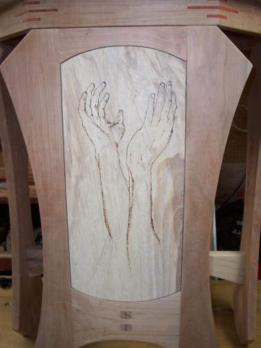 The hands of the potter burned into the face of the art stand.