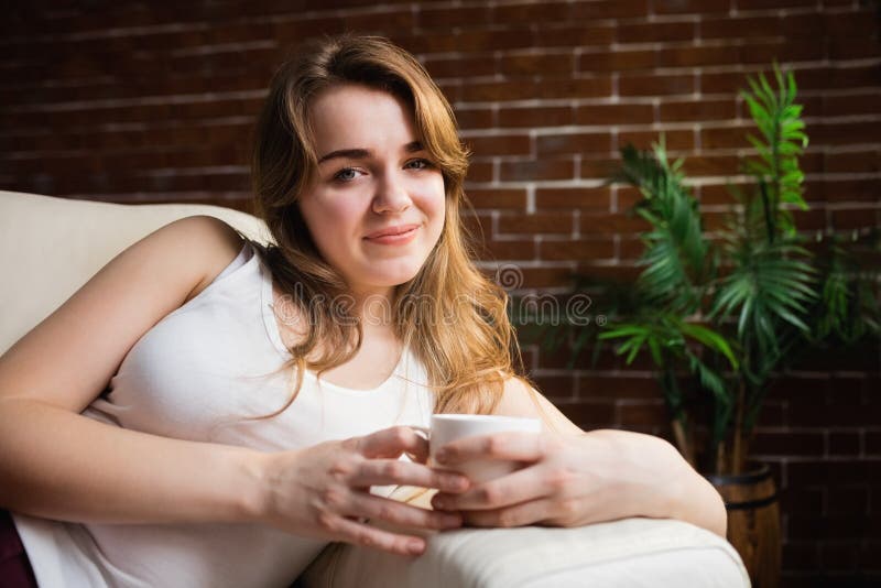 pretty-woman-drinking-coffee-lying-couch-living-room-66429717.jpg