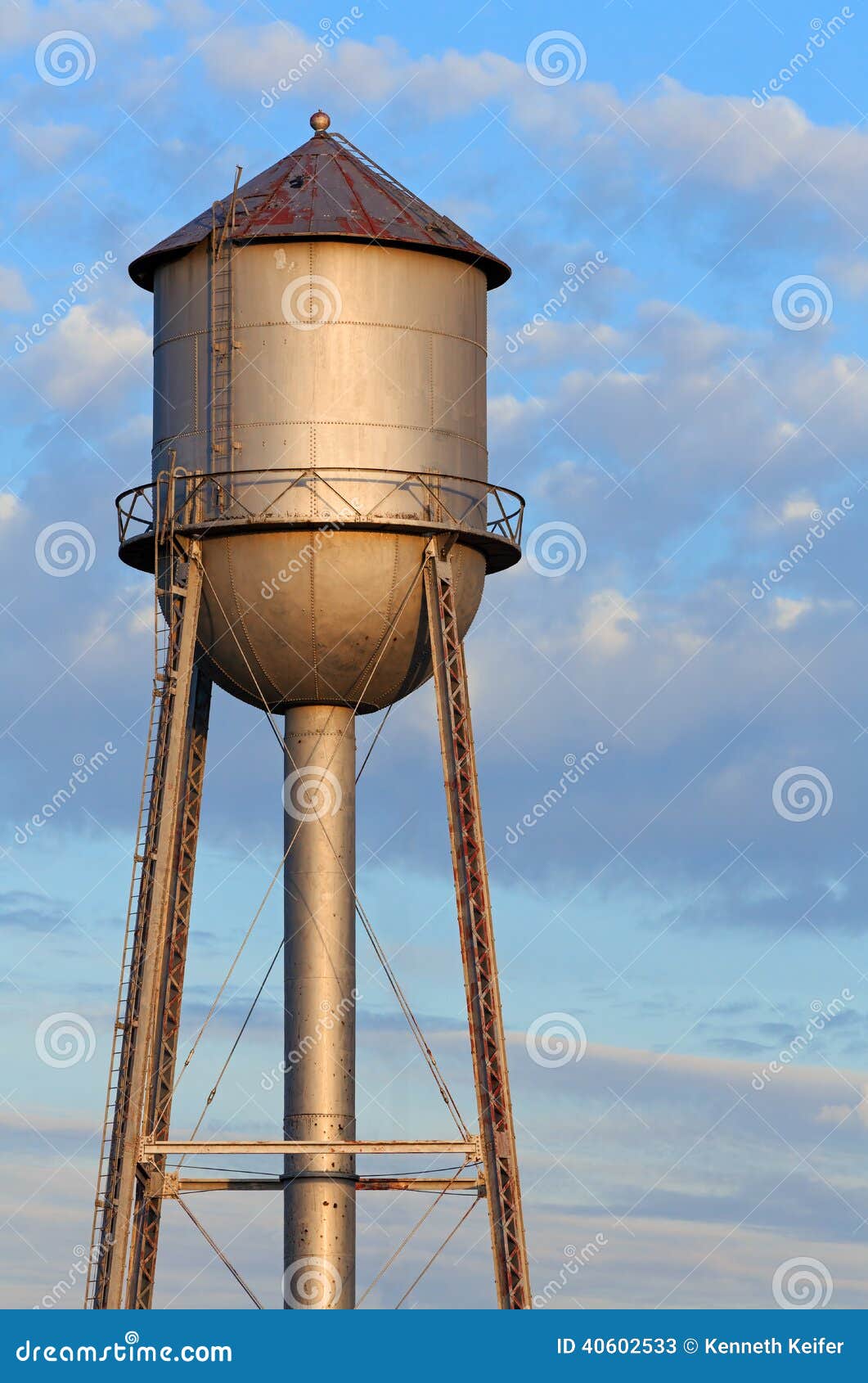 metal-water-tower-morning-sky-old-tank-light-sun-stands-tall-against-cloudy-blue-americas-midwest-40602533.jpg