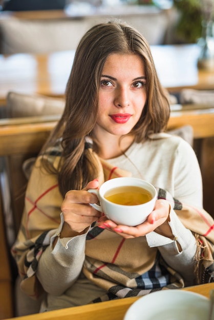 beautiful-young-woman-holding-herbal-tea-cup_23-2147975427.jpg