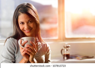 woman-drinking-coffee-home-sunrise-260nw-107813723.jpg