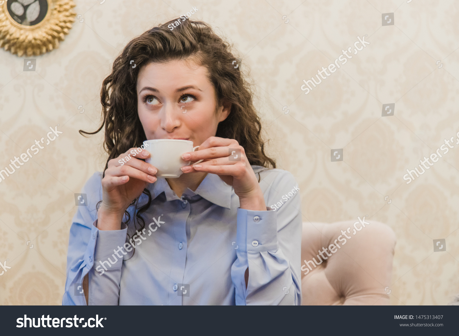 stock-photo-cup-of-coffee-in-women-s-hands-beautiful-young-brunette-woman-wearing-a-green-coat-sitting-at-a-1475313407.jpg