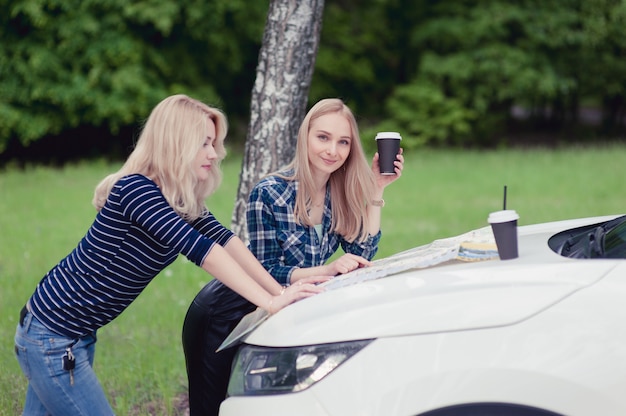 two-girls-stopped-road-get-directions-drink-coffee_105818-558.jpg