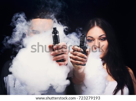 stock-photo-couple-vaping-unrecognizable-young-man-and-woman-in-the-clouds-of-smoke-showing-their-vapes-to-723279193.jpg